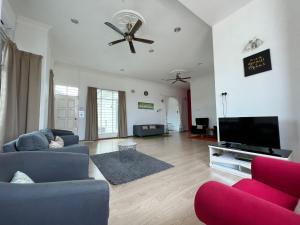 a living room with a couch and a ceiling fan at AmVilla in Kota Bharu