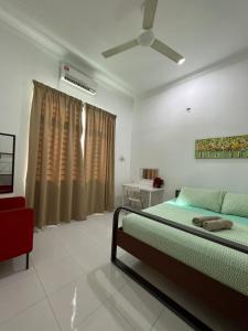 a bedroom with a bed and a ceiling fan at AmVilla in Kota Bharu