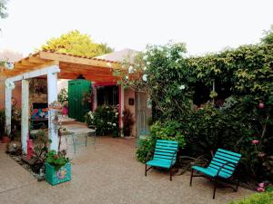 un patio con 2 sillas azules y una casa en El nogal en Tandil