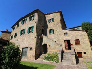 Un grand bâtiment en pierre avec des escaliers se trouve juste devant. dans l'établissement Belvilla by OYO Borgo Caprile, à Castiglion Fiorentino
