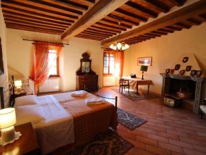 - une chambre avec un grand lit et une cheminée dans l'établissement Belvilla by OYO Borgo Caprile, à Castiglion Fiorentino