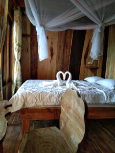 a bedroom with a bed with two swans on it at FOREST BREATH ECO-LODGE in Tân Phú