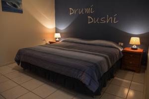 Camacuri Apartments في أورانيستاد: غرفة نوم بسرير وعلامة مكتوب عليها خندق دروبال