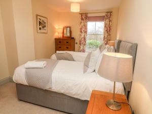 a bedroom with a bed and a lamp and a window at Anneside in Carnforth