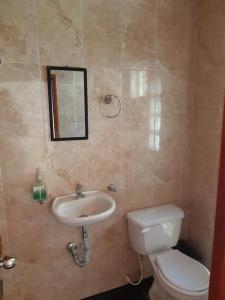 une salle de bain avec toilettes et lavabo dans l'établissement LA KINTA DE SAN PEDRO Casa Campestre con piscina, à Carmen de Apicalá