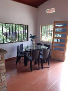 une salle à manger avec une table, des chaises et des fenêtres dans l'établissement LA KINTA DE SAN PEDRO Casa Campestre con piscina, à Carmen de Apicalá