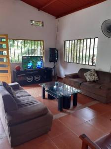 un salon avec deux canapés et une télévision dans l'établissement LA KINTA DE SAN PEDRO Casa Campestre con piscina, à Carmen de Apicalá