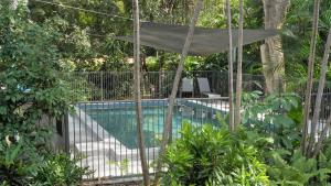 a swimming pool in a garden with a canopy over it at Dandaloo Gardens in Arcadia