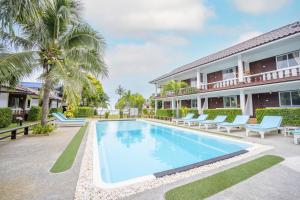 a villa with a swimming pool and palm trees at Assava Dive Resort - SHA Plus in Ko Tao