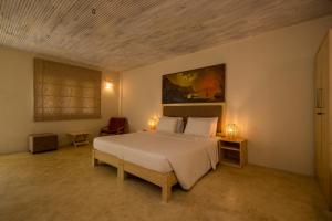 a bedroom with a white bed and a painting on the wall at Epique by Epic Collection in Unawatuna