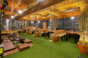 a room with tables and couches and plants in it at The Hosteller Jaipur in Jaipur