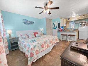 um quarto com uma cama e uma ventoinha de tecto em Tropic Terrace #23 - Beachfront Rental condo em St. Pete Beach