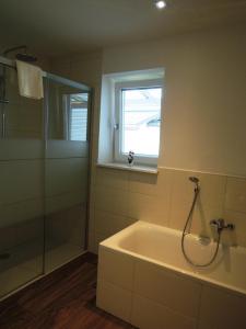 ein Bad mit einer Badewanne und einem Fenster in der Unterkunft K3 - Appartements in Strobl