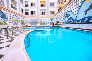 a swimming pool in a building with blue water at Rare New Marina Hotspot With Fast Free WIFI, Balcony & Pool - Western Standards - Sheraton Plaza 414 in Hurghada