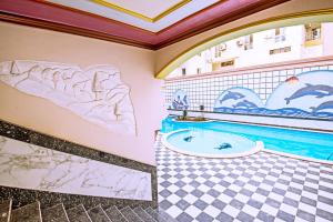a bathroom with a jacuzzi tub and paintings on the wall at Rare New Marina Hotspot With Fast Free WIFI, Balcony & Pool - Western Standards - Sheraton Plaza 414 in Hurghada