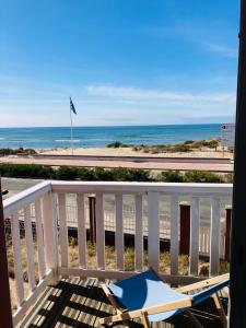 a balcony with a beach chair and the ocean at Grand appartement 1ch vue Océan in Soulac-sur-Mer