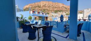 a table and chairs on a balcony with a view of the city at Suraj Haveli in Jodhpur
