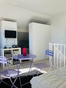 a room with a table and two chairs and a bed at Grand appartement 1ch vue Océan in Soulac-sur-Mer