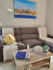 a living room with a couch and a coffee table at Ir-Rixa Holiday Penthouse in Għajnsielem