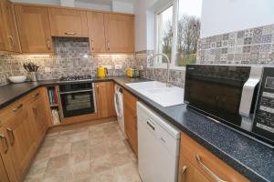 a kitchen with wooden cabinets and a black counter top at 12 Kel Avon in Truro