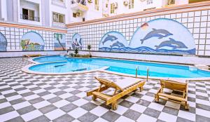 a swimming pool with two chairs and a mural of dolphins at Rare New Marina Hotspot With Pool & Fast Free WIFI - Western Standards - Sheraton Plaza 415 in Hurghada