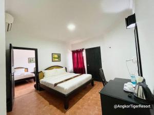 Postel nebo postele na pokoji v ubytování Angkor Tiger Resort