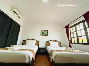 Postel nebo postele na pokoji v ubytování Angkor Tiger Resort