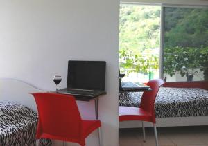 a table with a laptop and a glass of wine on it at Bahia B&B in Bahía de Caráquez