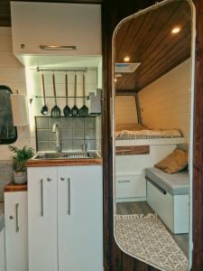 una cocina en una cabaña con lavabo y espejo en Geo Campers - Full time living camper rental in Kutaisi, Tbilisi, Batumi, Georgia, en Kutaisi