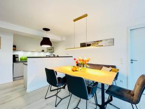 een keuken en eetkamer met een houten tafel en stoelen bij Haus Zudar / Prora in Binz