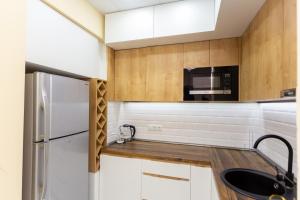 a kitchen with white cabinets and a black sink at BEST CHOICE in Old Tbilisi City Center in Tbilisi City