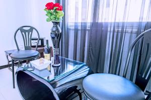 a glass table and two chairs with a vase with flowers on it at Rare 2BD Marina Hotspot With Pool, Fast Free WIFI & Balcony - 2 Kitchens & 2 Bathrooms - Western Standards - Sheraton Plaza 414-415 in Hurghada