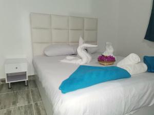 Una cama blanca con toallas y flores. en Sunshine Divers Club - Il Porto en Sharm El Sheikh
