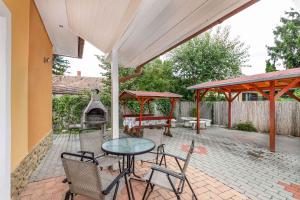 a patio with a table and chairs and a fireplace at Holiday home Balatonkeresztur 13 in Balatonkeresztúr