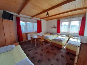 Cette chambre comprend 4 lits et une table. dans l'établissement Nad Potokiem, à Poronin