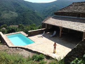 a man standing in front of a house with a swimming pool at MAISON DE CHARME EN ARDECHE DU SUD AVEC PISCINE in Beaumont