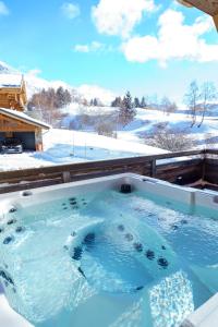 una vasca idromassaggio con neve per terra di Les Balcons du Golf a LʼAlpe-dʼHuez