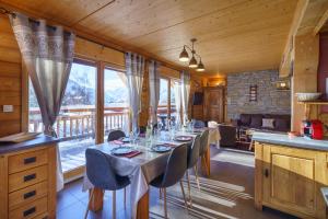 a dining room with a long table with chairs at Alpe d'Huez Houses - Les Balcons du Golf in L'Alpe-d'Huez