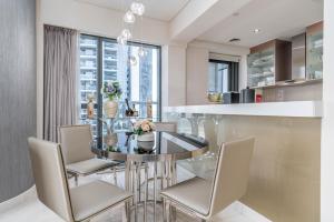 a kitchen and dining room with a glass table and chairs at Splendid 2-Bedroom Apartment in Paramount Towers in Dubai