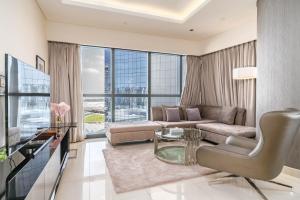 a living room with a couch and a glass table at Splendid 2-Bedroom Apartment in Paramount Towers in Dubai