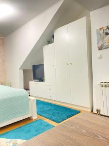una camera da letto con armadi bianchi e un tappeto blu di Apartment Dalia a Sarajevo Altre 25 foto
