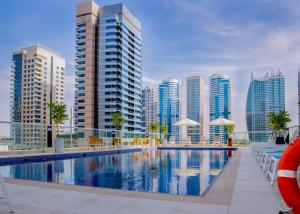 a swimming pool in front of some tall buildings at Royal Regency Suites Marina in Dubai