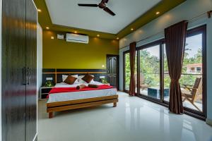 a bedroom with a bed and a large window at Om Shanti Residence in Canacona