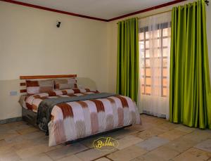 a bedroom with a bed with green curtains and a window at Bubbles Lodge Kinangop in South Kinangop
