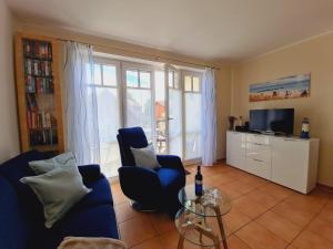 uma sala de estar com um sofá azul e uma mesa de vidro em Strandläufer Villa Rosita mit Garten em Rerik