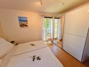 um quarto com 2 camas e uma varanda com o oceano em Strandläufer Villa Rosita mit Garten em Rerik