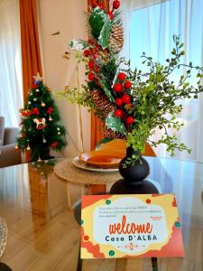 a sign on a table with a vase of flowers at Apartament Central "Casa D'Alba" in Alba Iulia