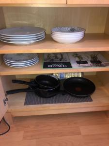 a shelf with plates and pans and dishes on it at Studio rénové avril 2024 wifi et parking in Le Port-Marly
