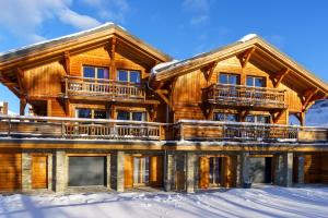 a log home in the snow at Les Balcons du Golf in L'Alpe-d'Huez