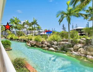 un río con rocas y palmeras en un complejo en Resort Queen Studio at Alex Beach Resort, en Alexandra Headland